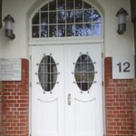 Eingangstür mit Oberlicht und rundem Glaseinsatz für Haus in Friesbauweise