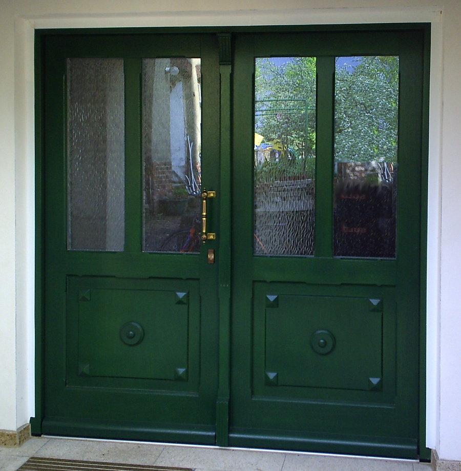 grüne Haustür mit Doppelflügel und Verzierungselementen