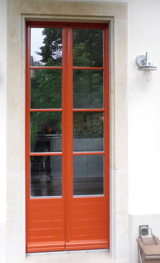rotbraune Tür mit Glaseinsatz und Sprossen für Einfamilienhaus